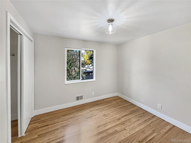 unfurnished bedroom featuring light hardwood / wood-style floors and a closet