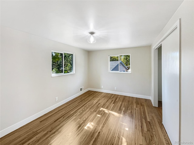 unfurnished bedroom with a closet and light wood-type flooring