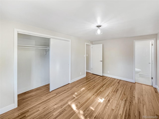 unfurnished bedroom featuring light hardwood / wood-style flooring, a closet, and ensuite bathroom