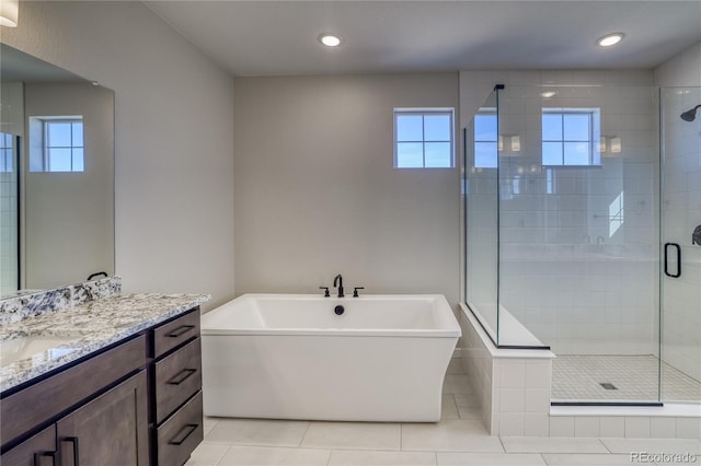 bathroom with recessed lighting, vanity, a soaking tub, a shower stall, and tile patterned floors