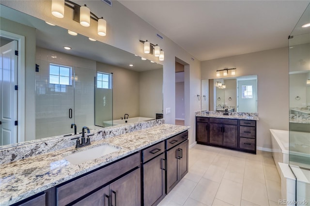 full bathroom with two vanities, a stall shower, a garden tub, and a sink