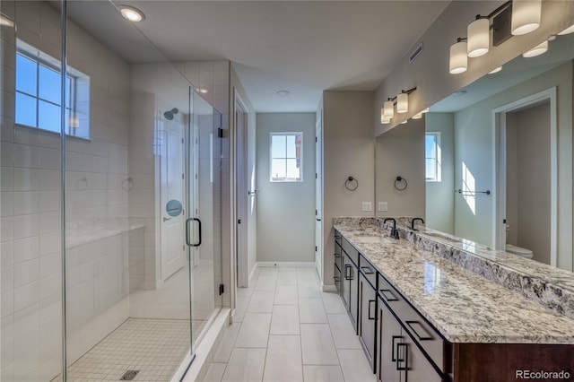 full bath with visible vents, toilet, a stall shower, vanity, and baseboards