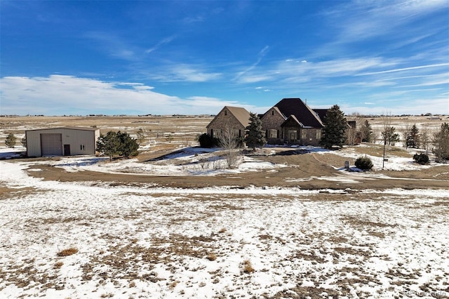 yard covered in snow with a garage and an outdoor structure