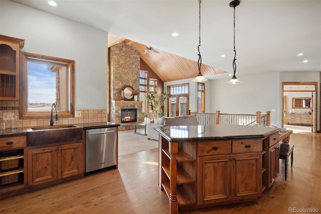 kitchen with sink, dishwasher, hanging light fixtures, a kitchen island, and decorative backsplash