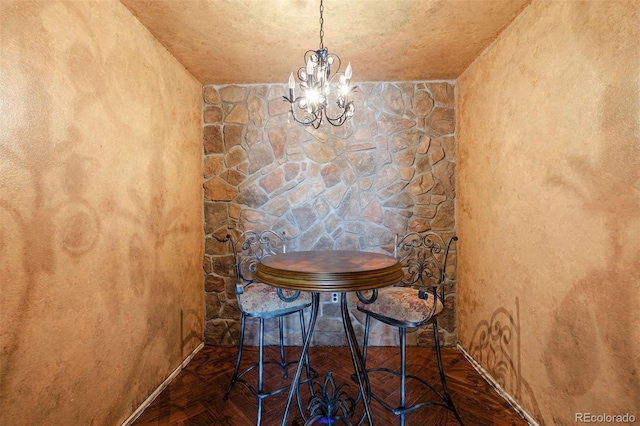 unfurnished dining area with a chandelier and dark parquet floors