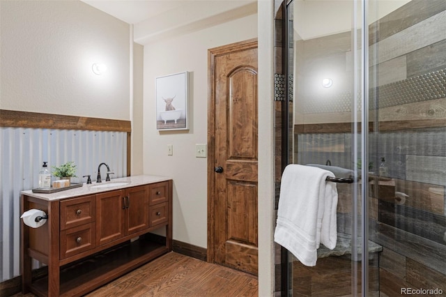 bathroom featuring a shower with door, vanity, and hardwood / wood-style floors