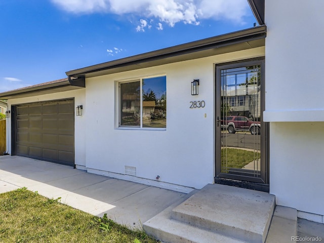 2830 E 99th Way, Thornton, CO 80229 - doorway to property featuring an attached garage, stucco siding, and concrete driveway
