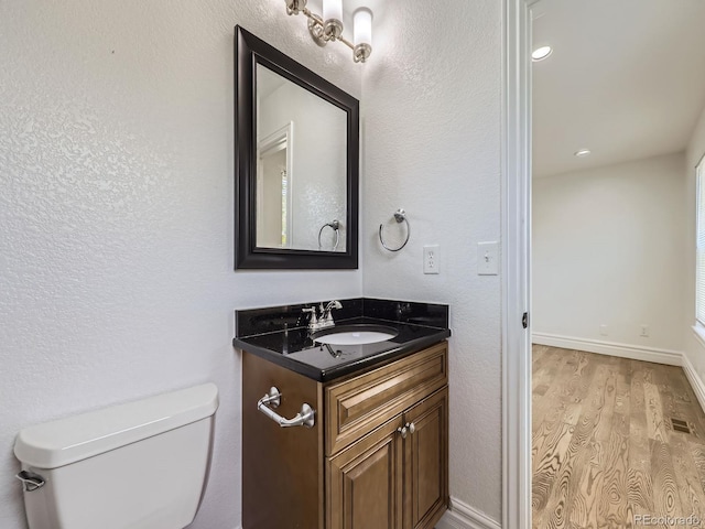 2830 E 99th Way, Thornton, CO 80229 - bathroom featuring vanity, wood finished floors, and a textured wall