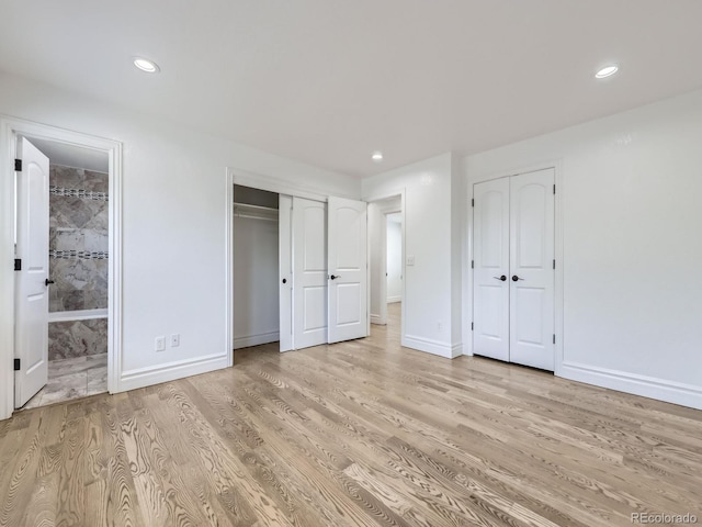 2830 E 99th Way, Thornton, CO 80229 - unfurnished bedroom with multiple closets, light wood-style flooring, connected bathroom, and recessed lighting