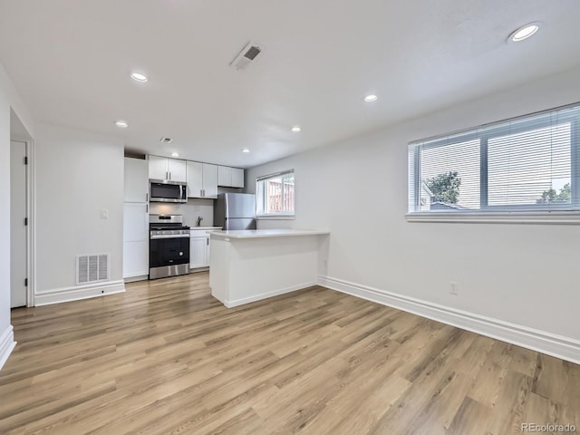 2830 E 99th Way, Thornton, CO 80229 - kitchen featuring appliances with stainless steel finishes, a peninsula, light wood-style floors, light countertops, and recessed lighting