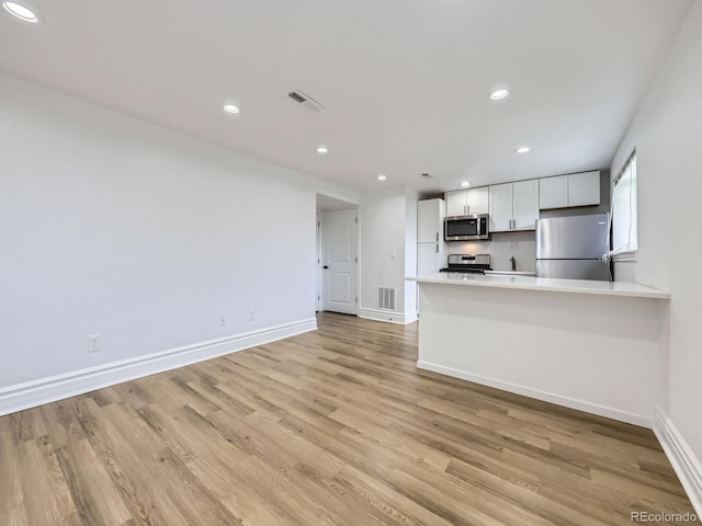 2830 E 99th Way, Thornton, CO 80229 - kitchen featuring stainless steel appliances, light wood-type flooring, recessed lighting, light countertops, and a peninsula