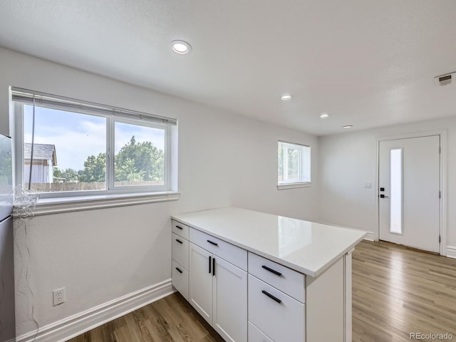 2830 E 99th Way, Thornton, CO 80229 - kitchen featuring a peninsula, wood finished floors, light countertops, white cabinetry, and recessed lighting