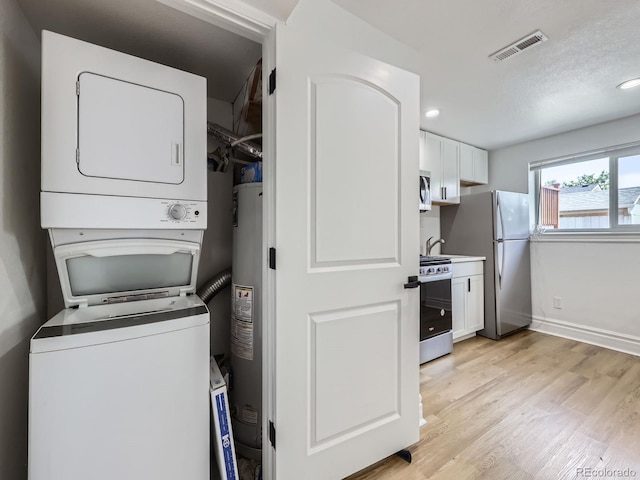 2830 E 99th Way, Thornton, CO 80229 - laundry room featuring stacked washer / drying machine, light wood-style floors, water heater, and recessed lighting