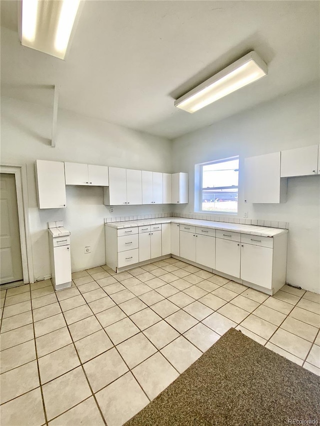 kitchen featuring light tile patterned floors and white cabinets