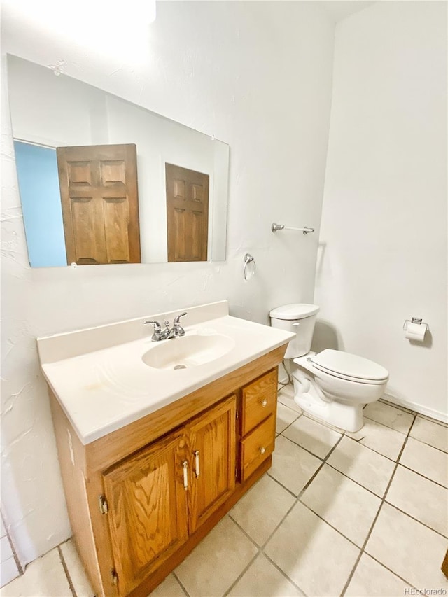 bathroom with vanity, toilet, and tile patterned flooring