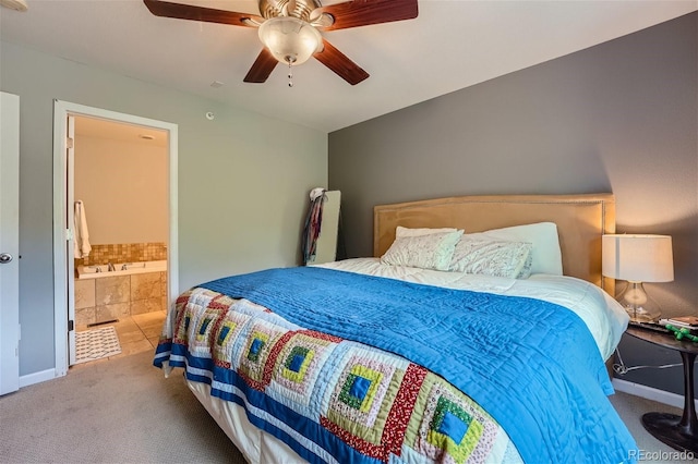 carpeted bedroom featuring baseboards, ensuite bath, and a ceiling fan