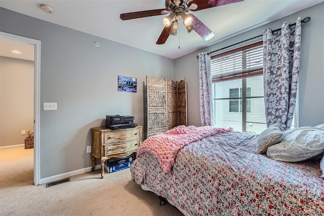 bedroom featuring baseboards, carpet floors, visible vents, and a ceiling fan