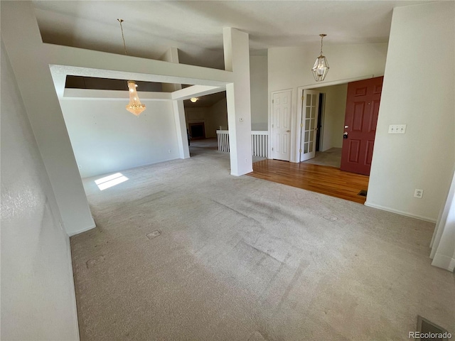 spare room featuring wood-type flooring and high vaulted ceiling