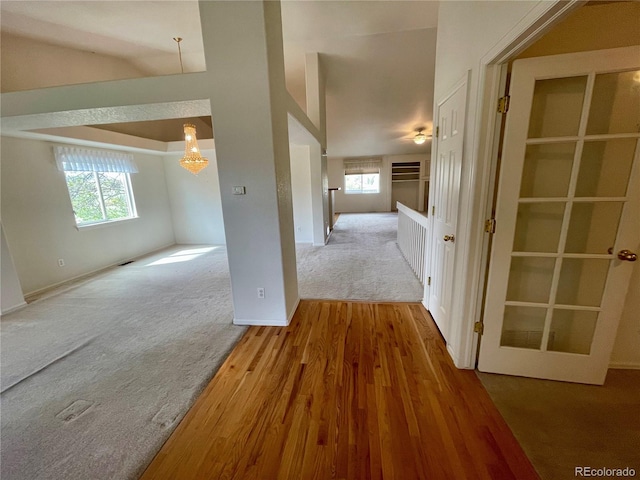 hall with hardwood / wood-style flooring and high vaulted ceiling