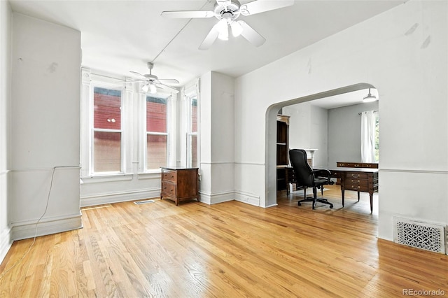 2346 N Gilpin St, Denver, CO 80205 - unfurnished room featuring light wood-style flooring, a ceiling fan, a desk, and arched walkways