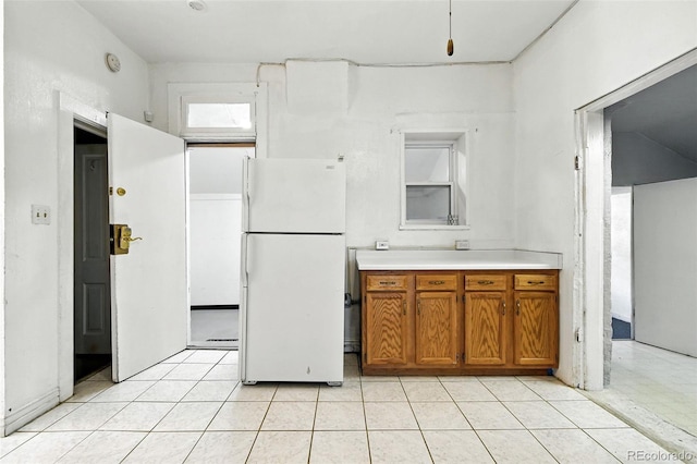 2346 N Gilpin St, Denver, CO 80205 - kitchen with freestanding refrigerator, brown cabinets, light countertops, and light tile patterned flooring