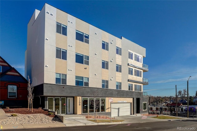1208 N Quitman St Unit 402, Denver, CO 80204 - view of building exterior with concrete driveway and a garage