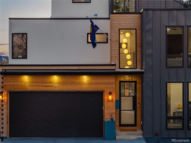 1655 Wolff St, Denver, CO 80204 - view of front facade with board and batten siding and an attached garage