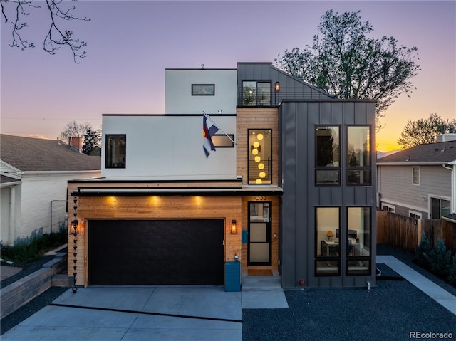 1655 Wolff St, Denver, CO 80204 - contemporary home featuring board and batten siding, an attached garage, and driveway