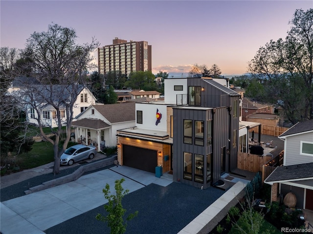 1655 Wolff St, Denver, CO 80204 - contemporary house featuring concrete driveway, board and batten siding, and an attached garage