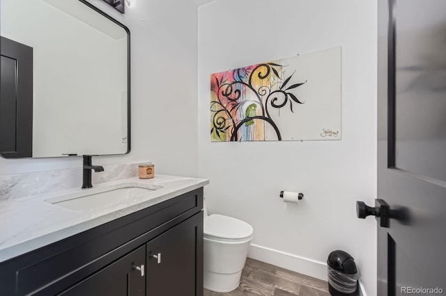 1655 Wolff St, Denver, CO 80204 - bathroom with vanity, toilet, wood finished floors, and baseboards