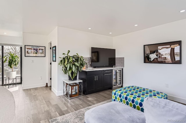 1655 Wolff St, Denver, CO 80204 - living room featuring light wood-style flooring, recessed lighting, baseboards, and bar area