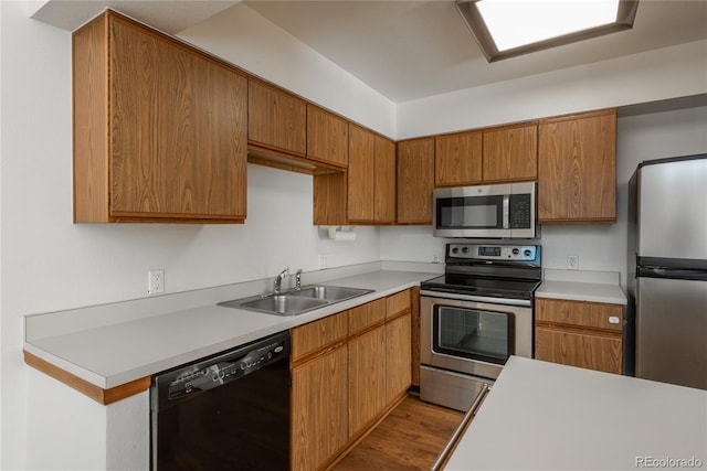 kitchen with sink, stainless steel appliances, and light wood-type flooring