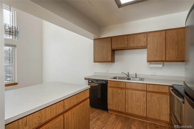 kitchen featuring sink, range, stainless steel refrigerator, dishwasher, and light hardwood / wood-style floors