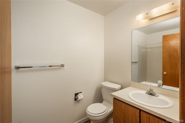 bathroom with vanity, a shower, and toilet