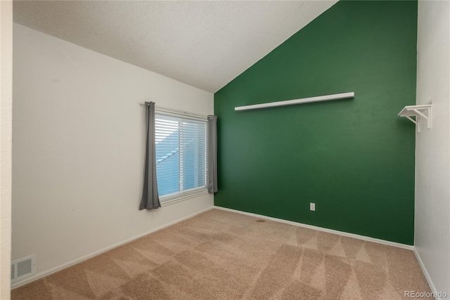 carpeted spare room featuring lofted ceiling