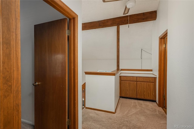 corridor with light colored carpet and beam ceiling