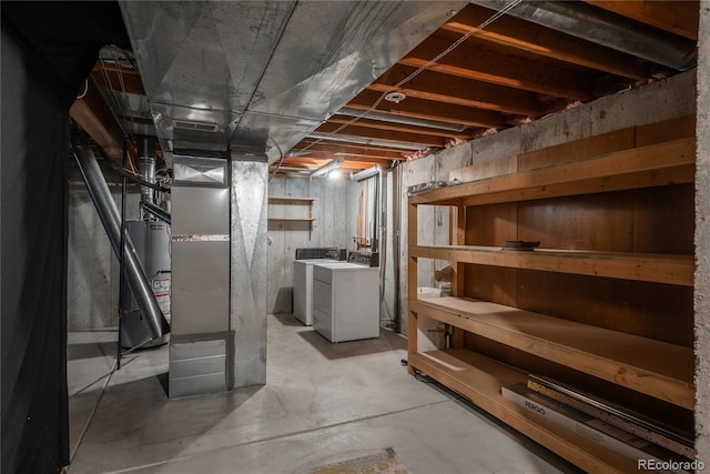 basement with gas water heater and washing machine and dryer