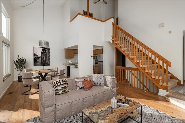 living room featuring hardwood / wood-style flooring and a towering ceiling