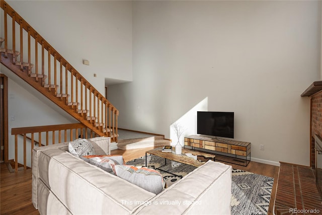 living room featuring a towering ceiling and wood-type flooring