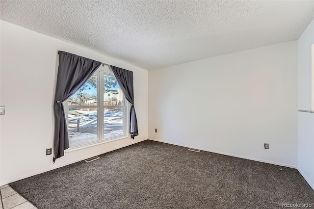 empty room with light colored carpet and a textured ceiling