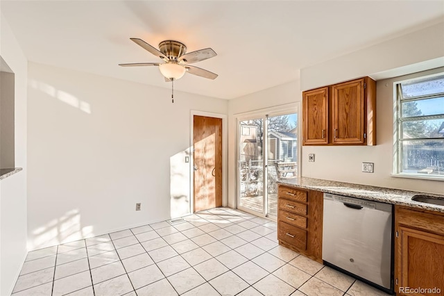 kitchen featuring dishwasher, sink, light tile patterned floors, ceiling fan, and light stone countertops