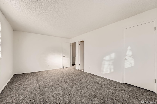 carpeted empty room featuring a textured ceiling