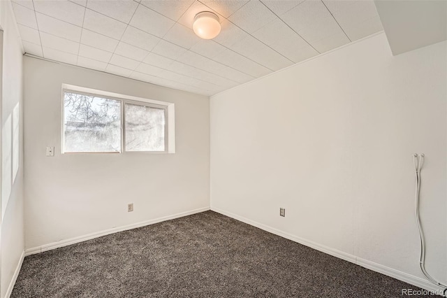 spare room featuring dark colored carpet