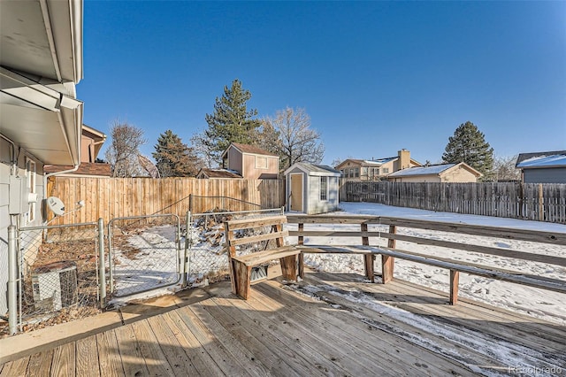 snow covered deck with a storage shed