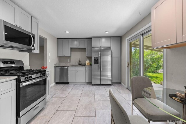 8305 Eaton Way, Arvada, CO 80003 - kitchen featuring stainless steel appliances, gray cabinetry, baseboards, recessed lighting, and a sink