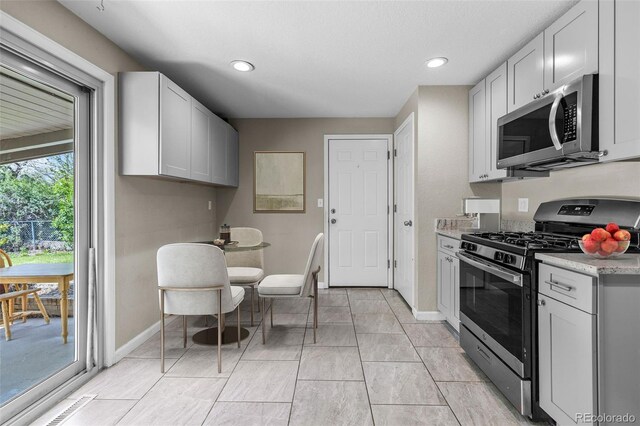 8305 Eaton Way, Arvada, CO 80003 - kitchen with appliances with stainless steel finishes, baseboards, light countertops, and recessed lighting