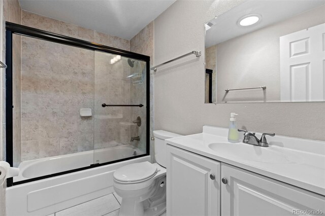 8305 Eaton Way, Arvada, CO 80003 - full bathroom featuring toilet, vanity, and bath / shower combo with glass door