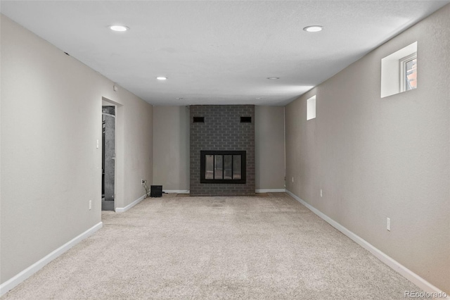 8305 Eaton Way, Arvada, CO 80003 - unfurnished living room featuring light carpet, a brick fireplace, recessed lighting, and baseboards