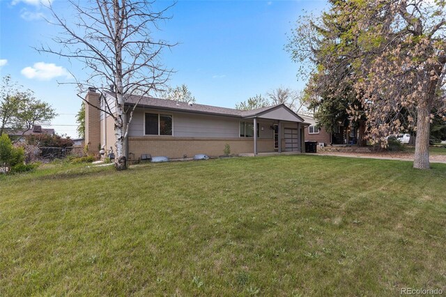 8305 Eaton Way, Arvada, CO 80003 - view of front of house with brick siding, a front yard, a chimney, and a garage