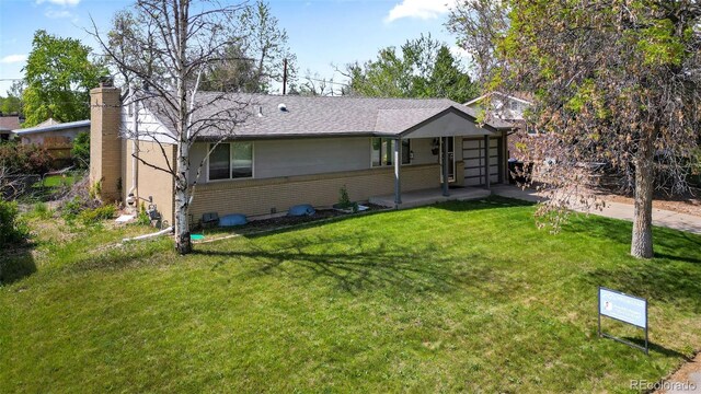 8305 Eaton Way, Arvada, CO 80003 - view of front of house featuring a front yard, a garage, roof with shingles, and a chimney